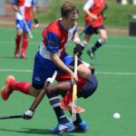 man in red and blue jersey shirt playing hockey