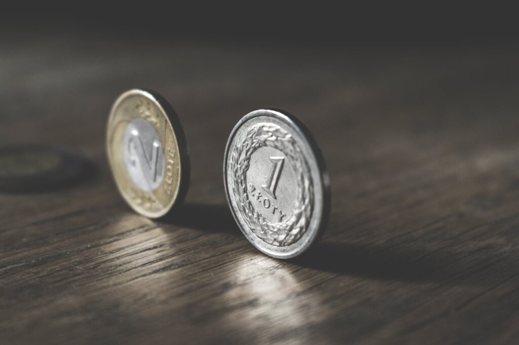 photo of two gold colored and silver colored coins standing on floor